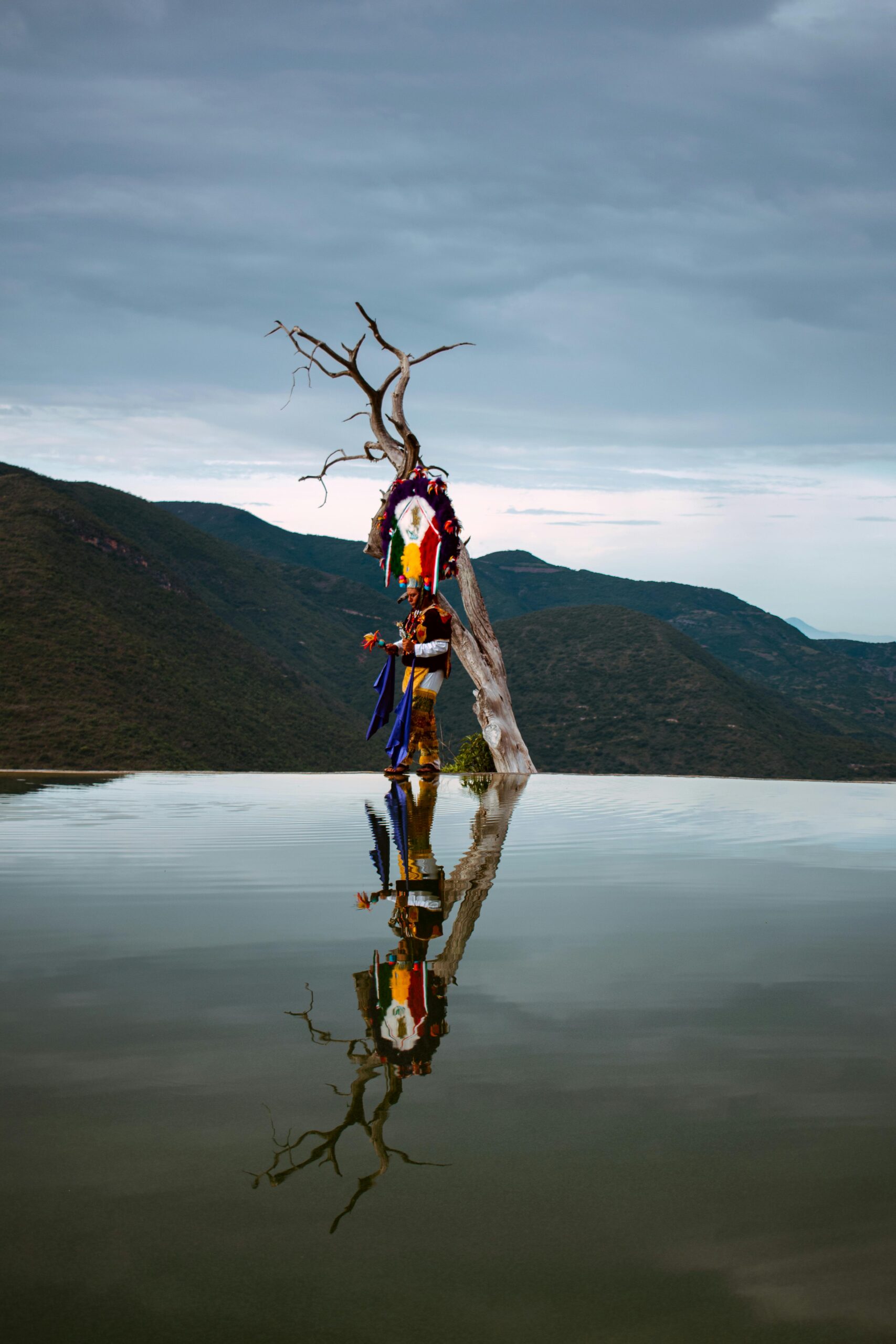 Vivid cultural display reflected in the serene waters of Hierve el Agua, Oaxaca.
